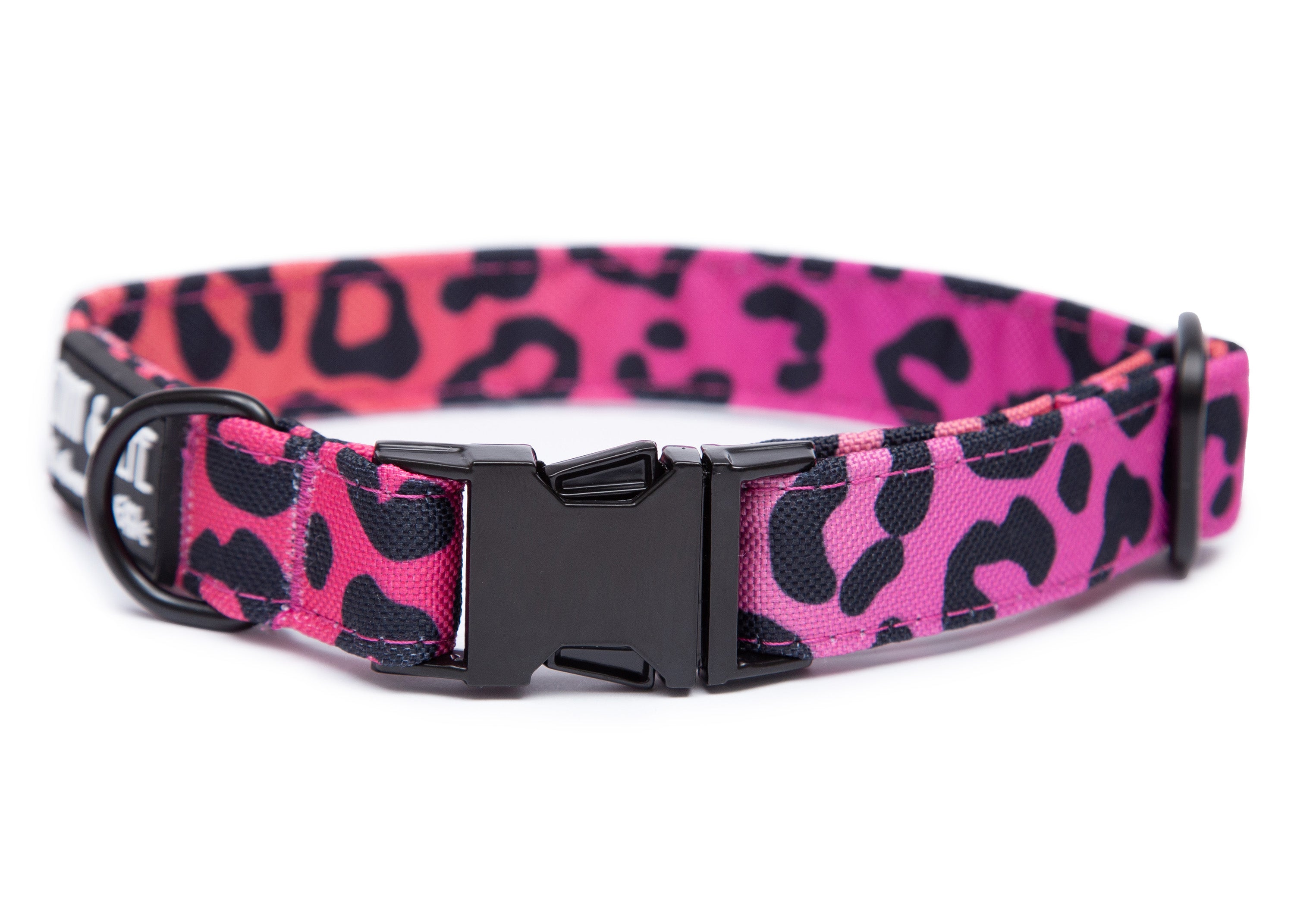 Pinkes Hundehalsband in Leomuster. Das Halsband verfügt über eine robuste, schwarzer Steckschnalle mit „EMMY & PEPE“-Gravur sowie schwarzem Metallring. Freigestellte Produktaufnahme auf weißem Hintergrund.