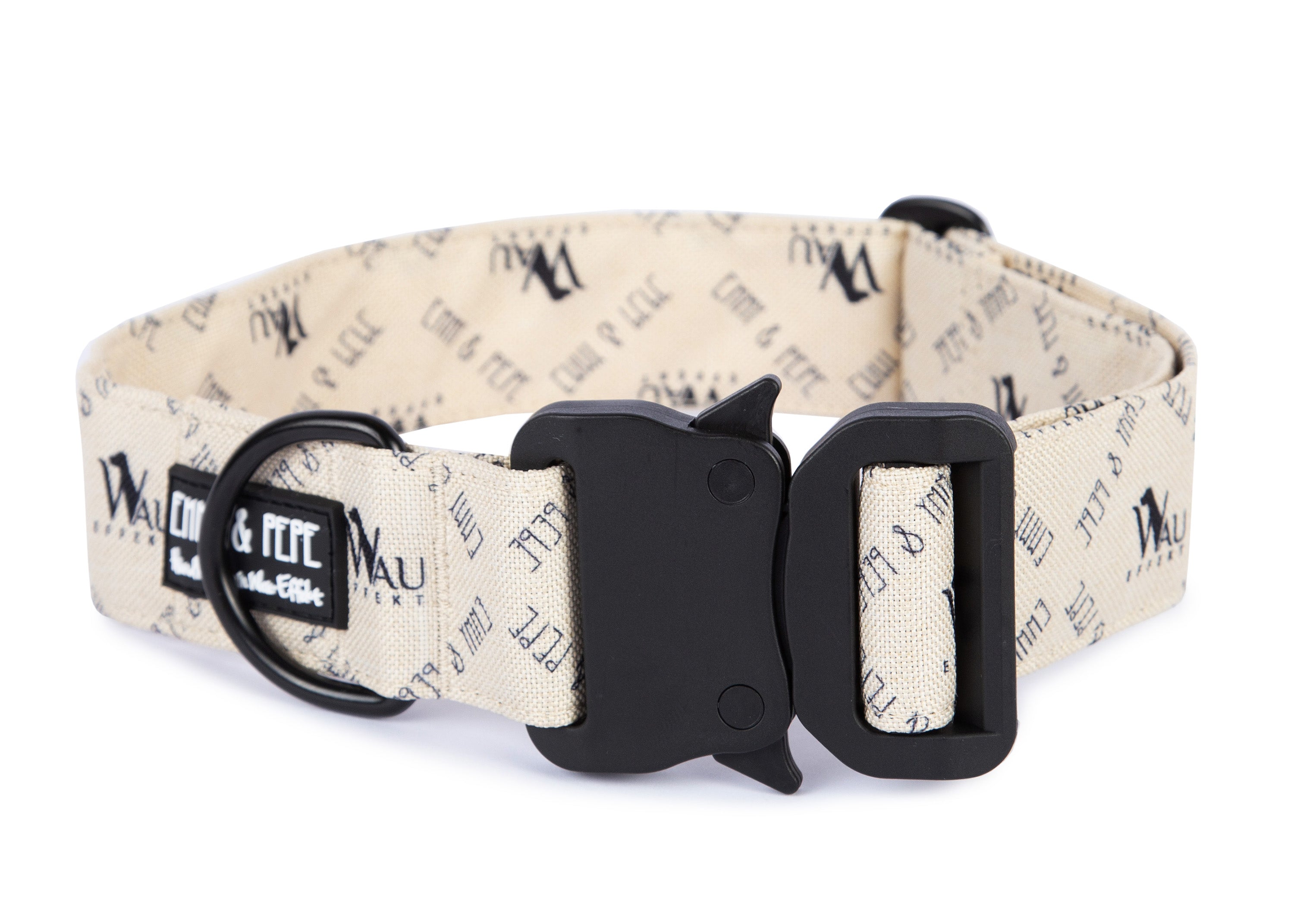 Cremefarbenes Hundehalsband mit Wau-Effekt Aufdruck aus Stoff mit schwarzem Kunststoff-Sicherheitsverschluss und schwarzem Metallring zur Befestigung einer Leine. Das Halsband ist vor weißem Hintergrund fotografiert und zeigt eine breite, verstellbare Ausführung mit gepolsterter Innenseite. Auf einem kleinen Etikett am Ring ist ein Markenlogo zu erkennen.