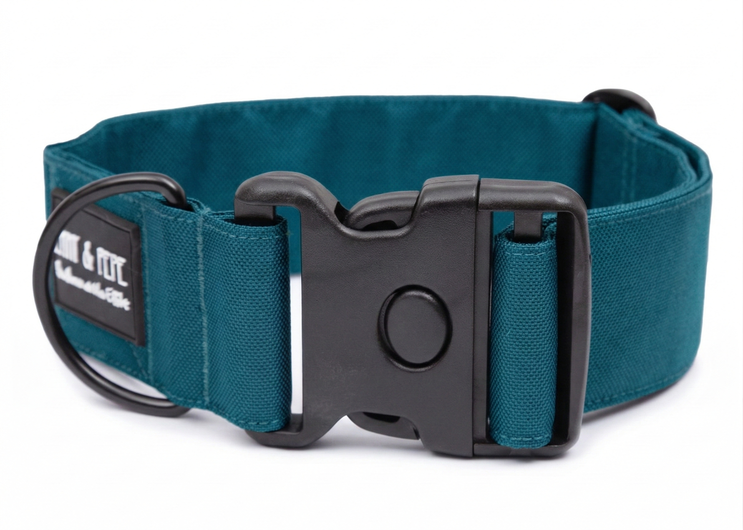 Blaues Hundehalsband aus Stoff mit schwarzem Kunststoff-Schnellverschluss und schwarzem Metallring zur Befestigung einer Leine. Das Halsband ist vor weißem Hintergrund fotografiert und zeigt eine breite, verstellbare Ausführung mit gepolsterter Innenseite. Auf einem kleinen Etikett am Ring ist ein Markenlogo zu erkennen.