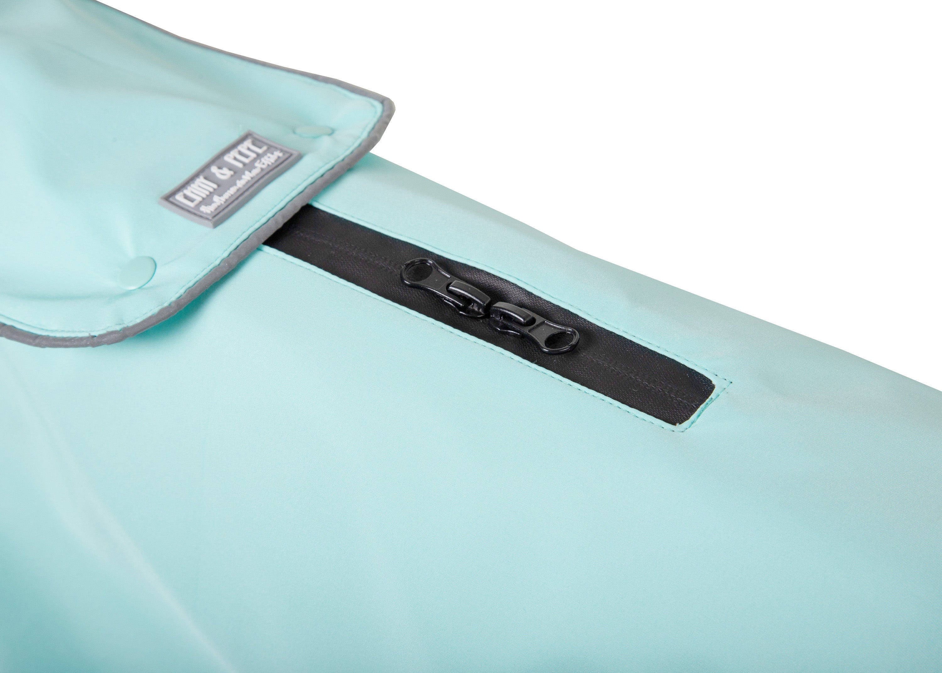 Detailansicht des Wau-Coat 2-in-1 Hundemantels in Mint mit wasserdichtem Reißverschluss für Leinenöffnung und reflektierenden Details