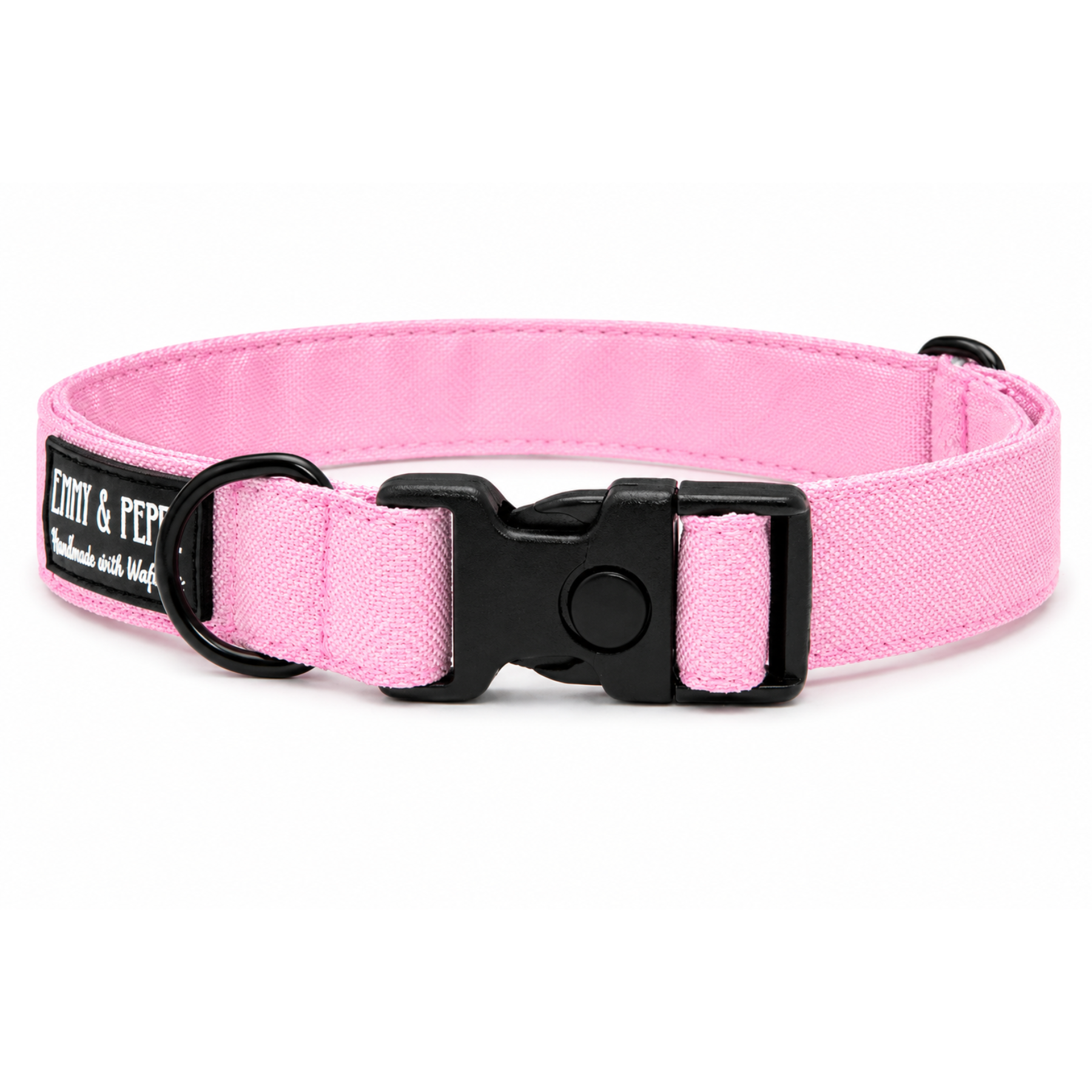 Rosafarbenes Hundehalsband aus Stoff mit schwarzem Kunststoff-Schnellverschluss und schwarzem Metallring zur Befestigung einer Leine. Das Halsband ist vor weißem Hintergrund fotografiert und zeigt eine breite, verstellbare Ausführung mit gepolsterter Innenseite. Auf einem kleinen Etikett am Ring ist ein Markenlogo zu erkennen.