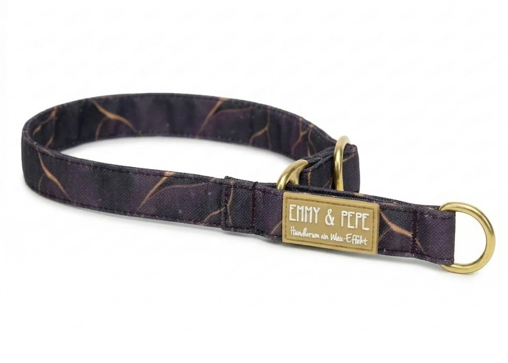 Ein elegantes, dunkelviolettes Hundehalsband mit einem feinen, goldfarbenen Marmor-Muster und hochwertigen Messing-Beschlägen. Auf einem beige-goldenen Gummipatch ist oben das Logo „EMMY & PEPE“ und darunter der Slogan „Hundherum ein Wau-Effekt“ in weißer Schreibschrift zu sehen. Das Halsband liegt freigestellt auf einem weißen Hintergrund.