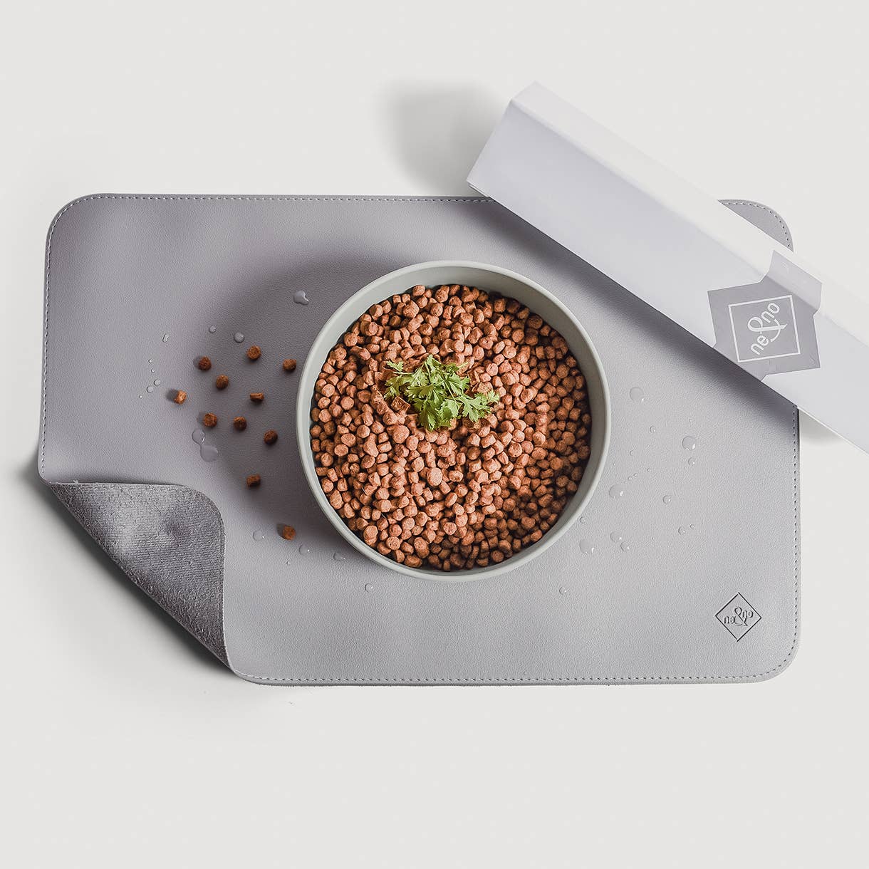 Detailaufnahme der Napfunterlage aus veganem Leder in Grau mit Futternapf