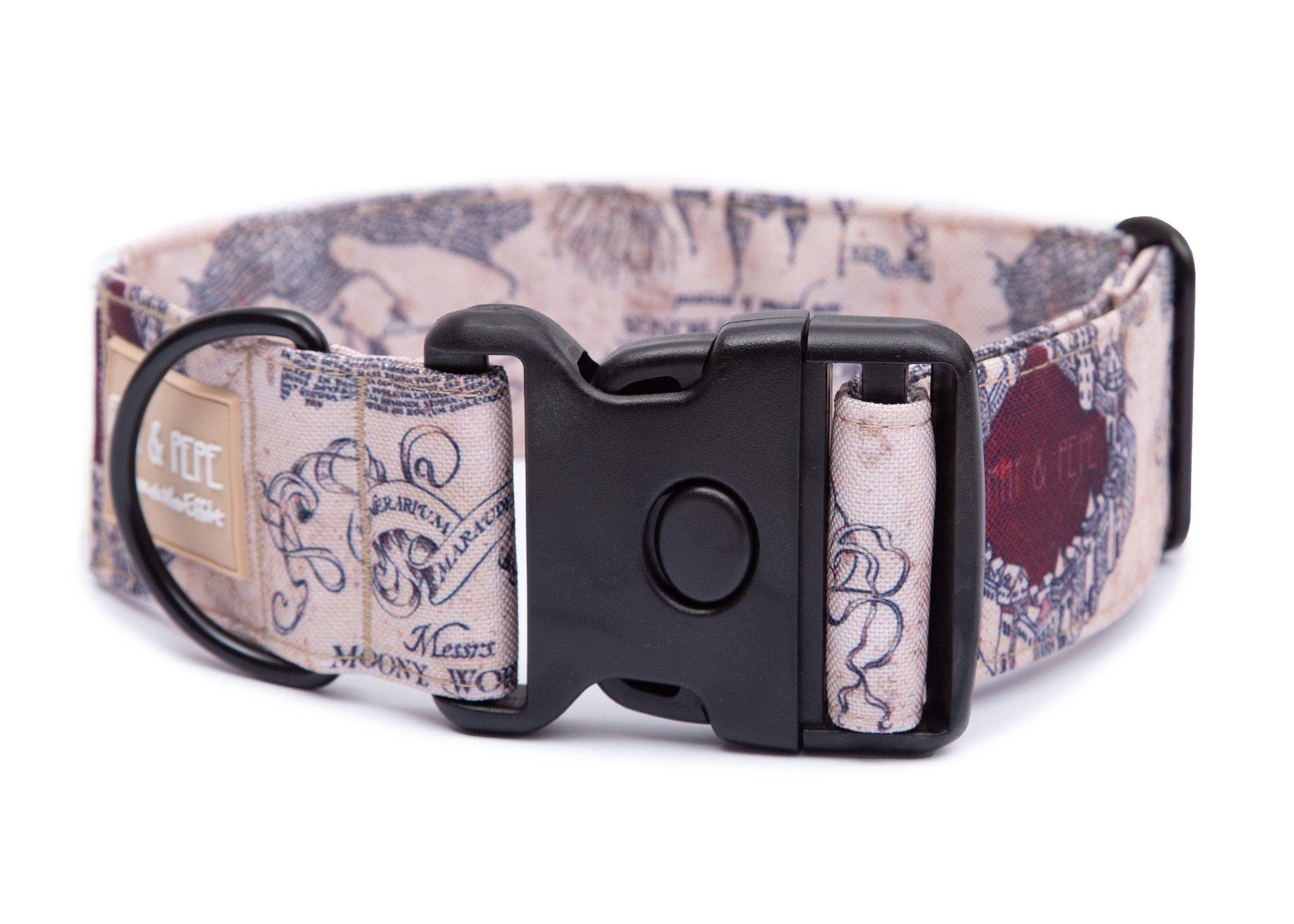 Hell gemustertes Hundehalsband aus Stoff mit schwarzem Kunststoff-Schnellverschluss und schwarzem  Metallring zur Befestigung einer Leine. Das Halsband ist vor weißem Hintergrund fotografiert und zeigt eine breite, verstellbare Ausführung mit gepolsterter Innenseite. Auf einem kleinen Etikett am Ring ist ein Markenlogo zu erkennen.