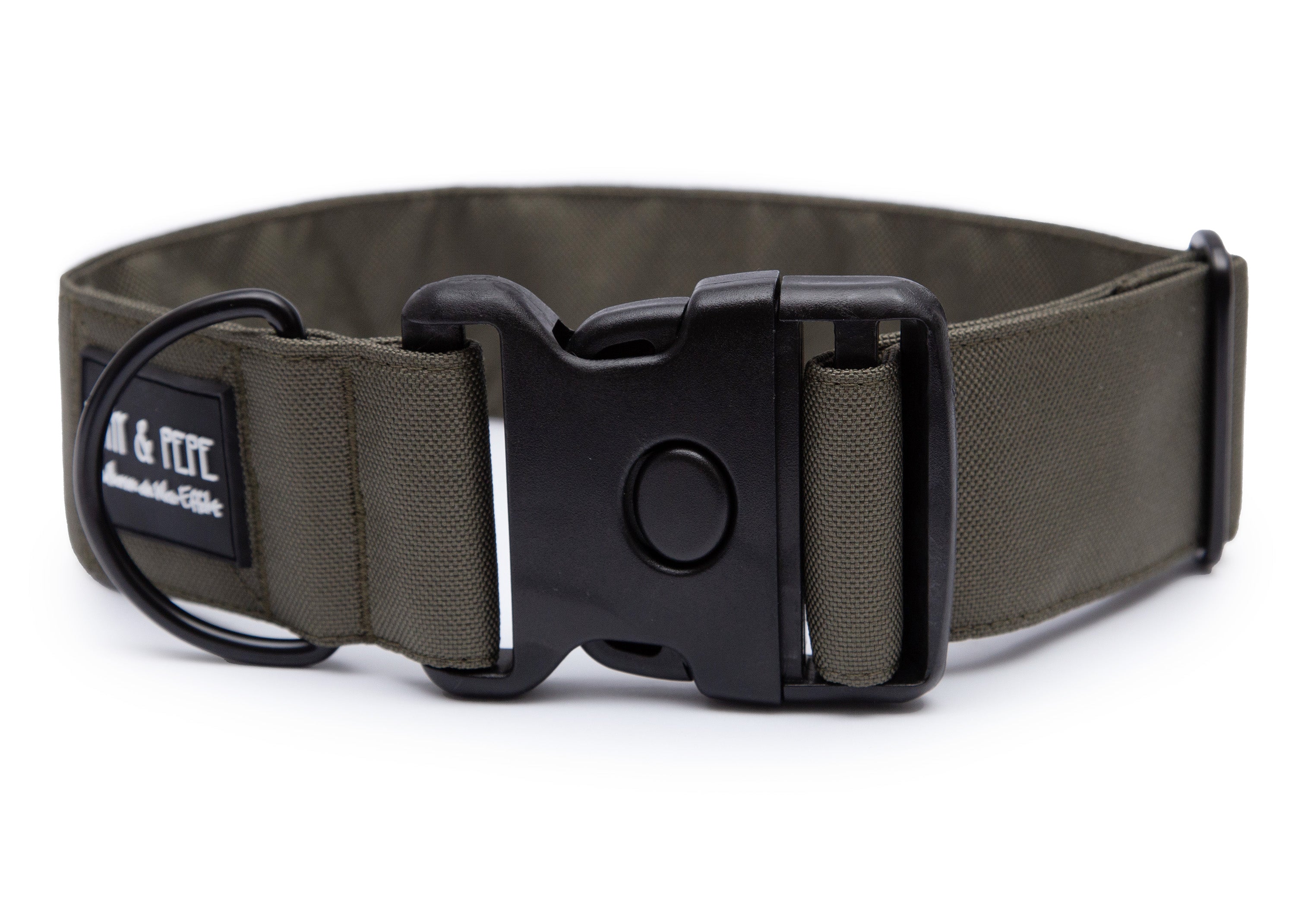 Olivefarbenes Hundehalsband aus Stoff mit schwarzem Kunststoff-Schnellverschluss und schwarzem Metallring zur Befestigung einer Leine. Das Halsband ist vor weißem Hintergrund fotografiert und zeigt eine breite, verstellbare Ausführung mit gepolsterter Innenseite. Auf einem kleinen Etikett am Ring ist ein Markenlogo zu erkennen.