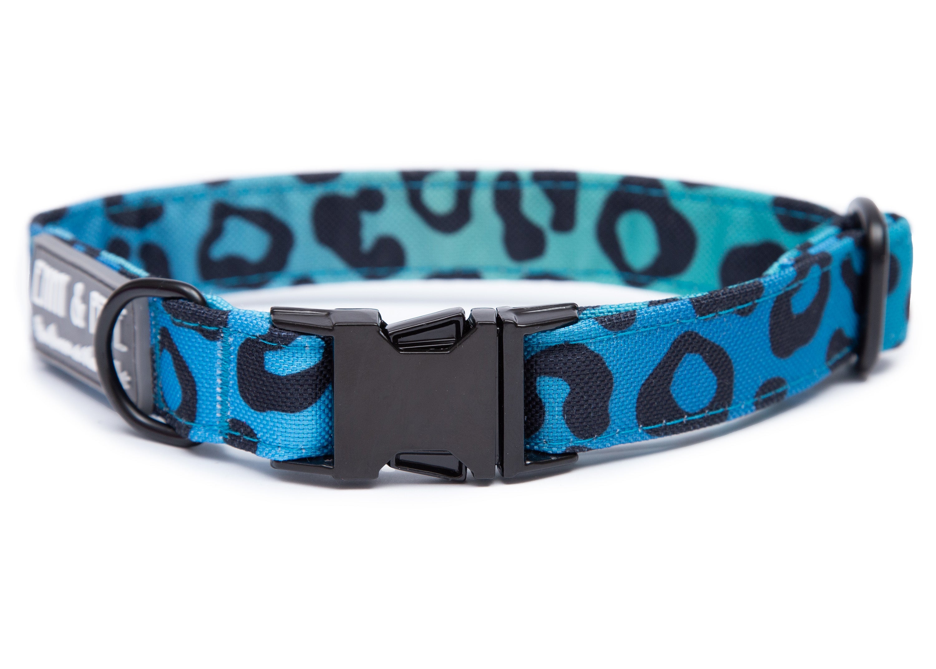 Blaues Hundehalsband in Leomuster. Das Halsband verfügt über eine robuste, schwarzer Steckschnalle mit „EMMY & PEPE“-Gravur sowie schwarzem Metallring. Freigestellte Produktaufnahme auf weißem Hintergrund.