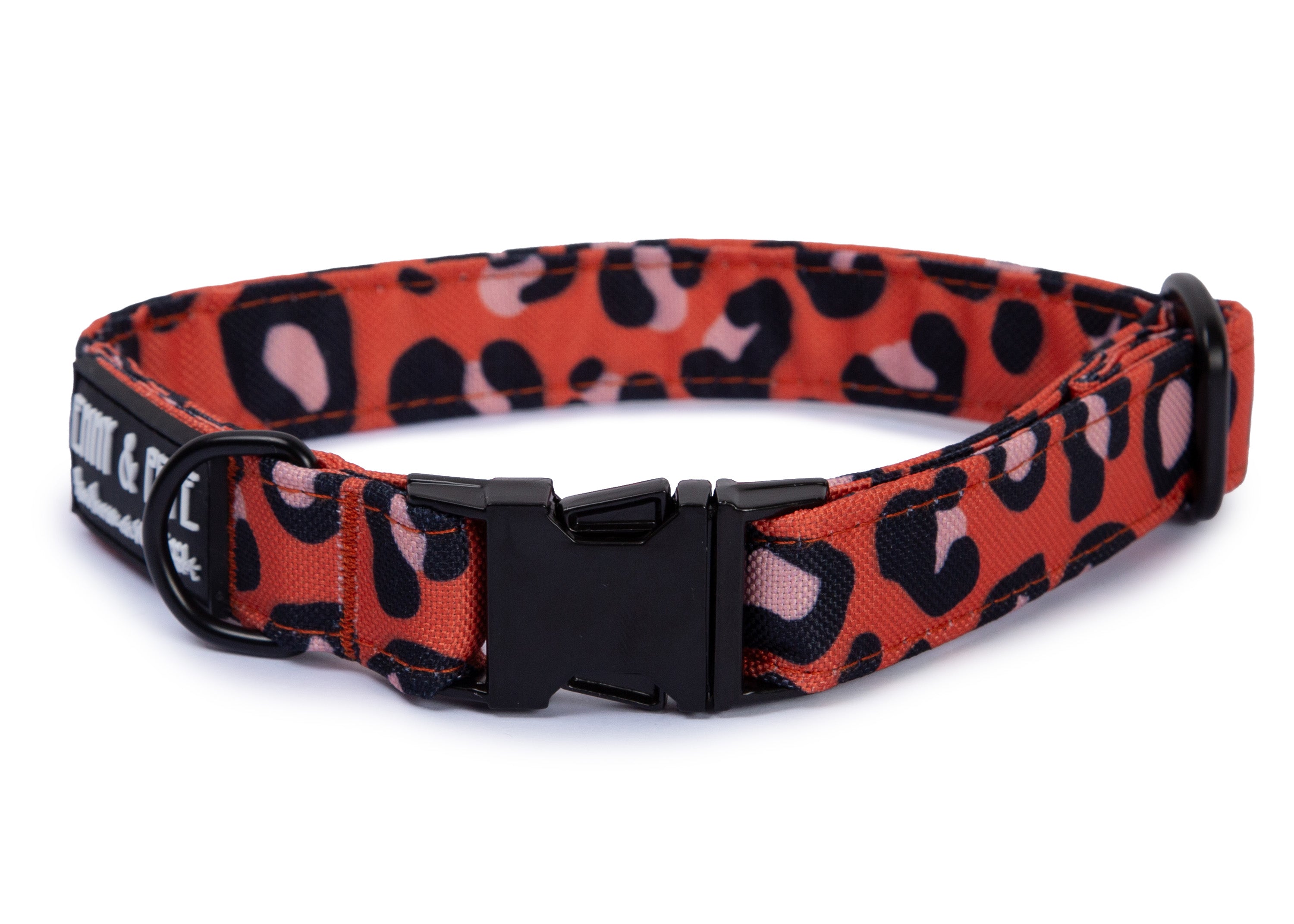 Orangenes Hundehalsband in Leomuster. Das Halsband verfügt über eine robuste, schwarzer Steckschnalle mit „EMMY & PEPE“-Gravur sowie schwarzem Metallring. Freigestellte Produktaufnahme auf weißem Hintergrund.