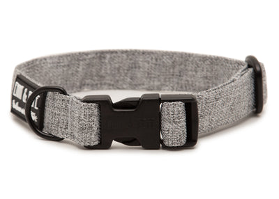 Graues Hundehalsband. Das Halsband verfügt über eine robuste, schwarze Steckschnalle mit „EMMY & PEPE“-Gravur sowie goldenem Metallring. Freigestellte Produktaufnahme auf weißem Hintergrund.