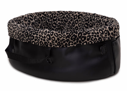  Wau-Snuggle Reisebett mit robustem schwarzen Kunstleder an der Außenseite und einem weichen, beigen Innenfutter mit schwarzem Leopardenmuster in oval Rückseite
