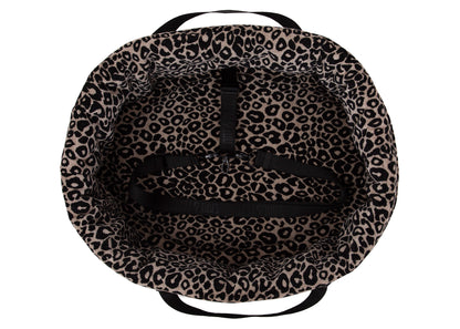 Wau-Snuggle Reisebett in oval mit einem weichen, beigen Innenfutter mit schwarzem Leopardenmuster und schwarzen Gurten zum Anschnallen innen