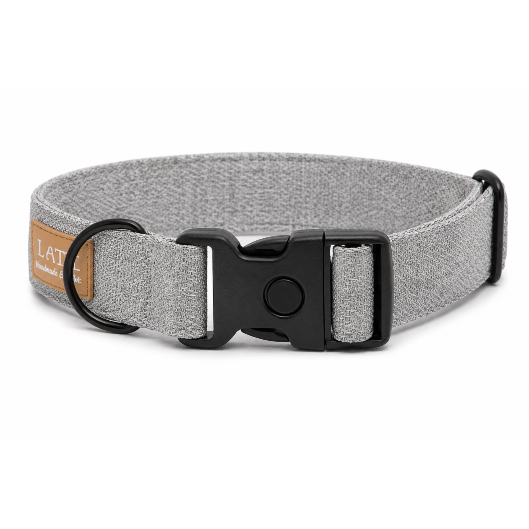 Graues Hundehalsband aus Stoff mit schwarzem Kunststoff-Schnellverschluss und schwarzem Metallring zur Befestigung einer Leine. Das Halsband ist vor weißem Hintergrund fotografiert und zeigt eine breite, verstellbare Ausführung mit gepolsterter Innenseite. Auf einem kleinen Etikett am Ring ist ein Markenlogo zu erkennen.