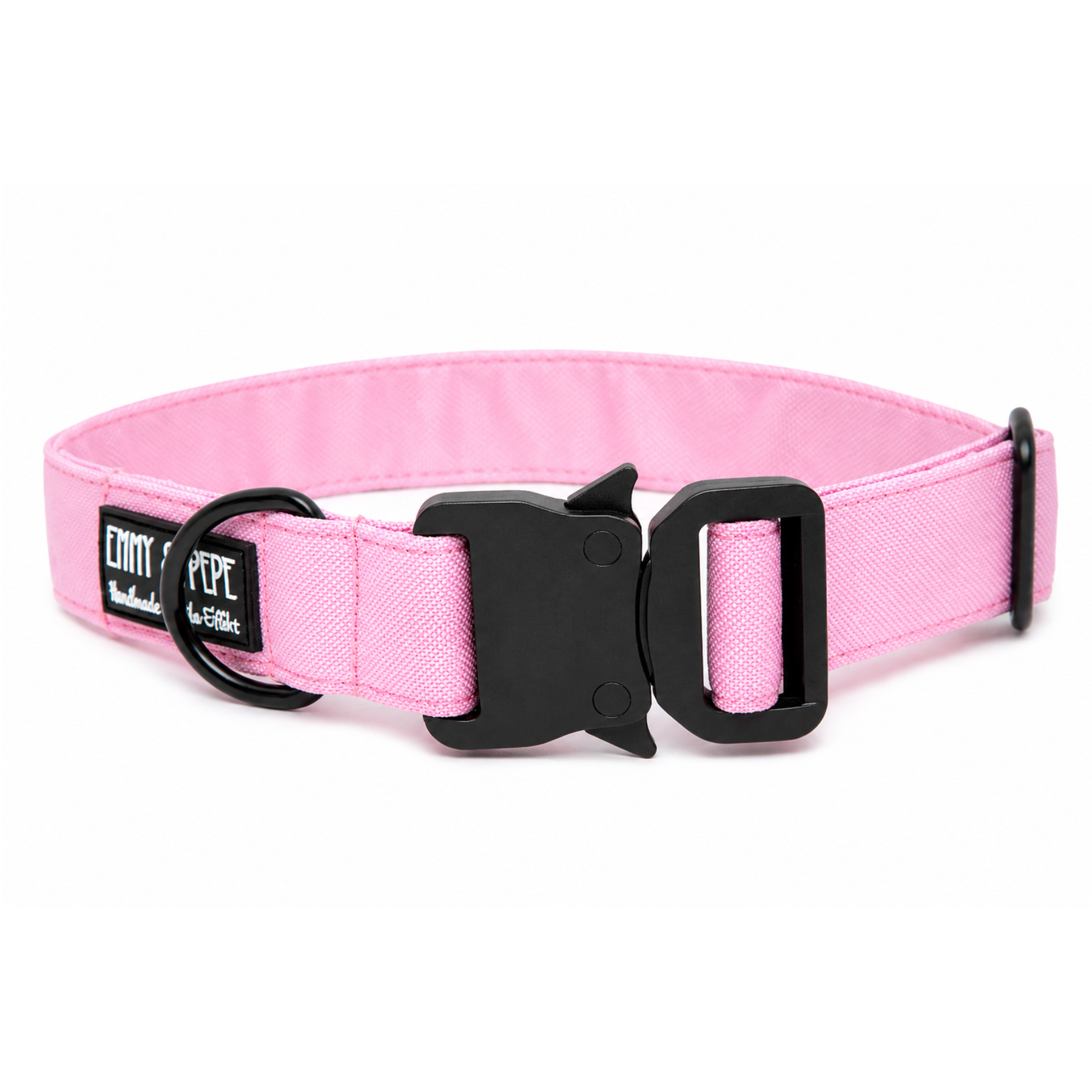 Rosanes Hundehalsband aus Stoff mit schwarzem Kunststoff-Sicherheitsverschluss und schwarzem Metallring zur Befestigung einer Leine. Das Halsband ist vor weißem Hintergrund fotografiert und zeigt eine breite, verstellbare Ausführung mit gepolsterter Innenseite. Auf einem kleinen Etikett am Ring ist ein Markenlogo zu erkennen.