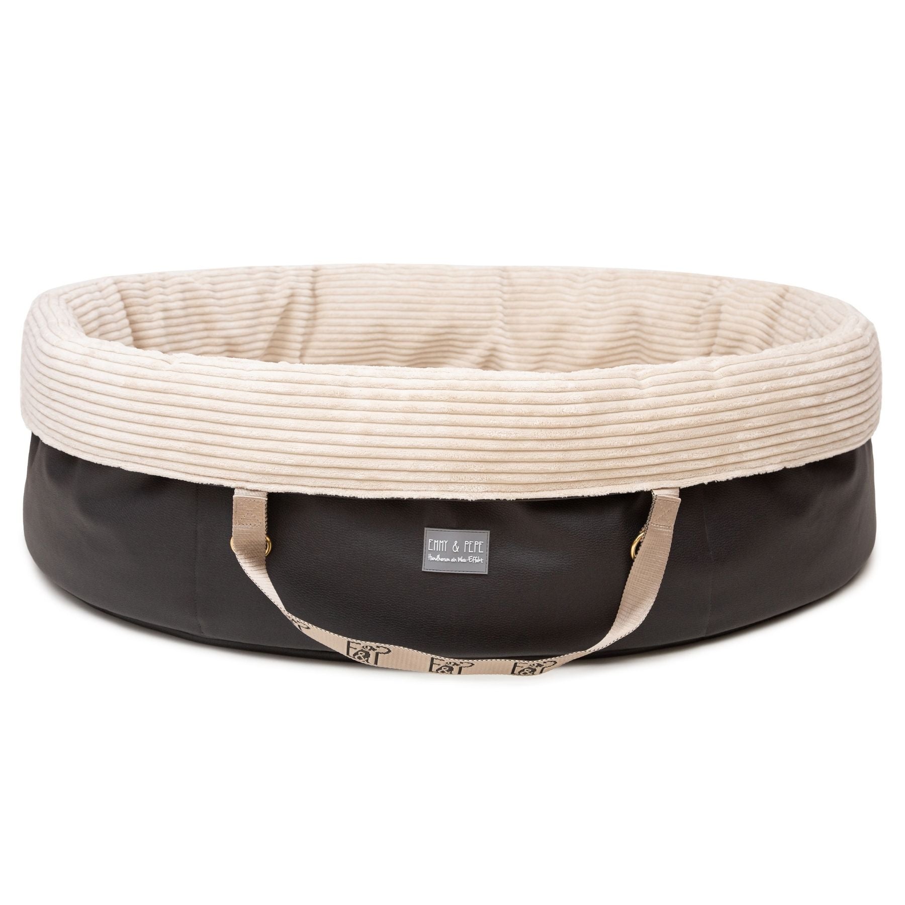 Freigestelltes ovales Wau-Snuggle Cord Creme Hundekörbchen für unterwegs von EMMY & PEPE mit dunklem Kunstleder und weichem cremefarbenem Cordstoff innen.