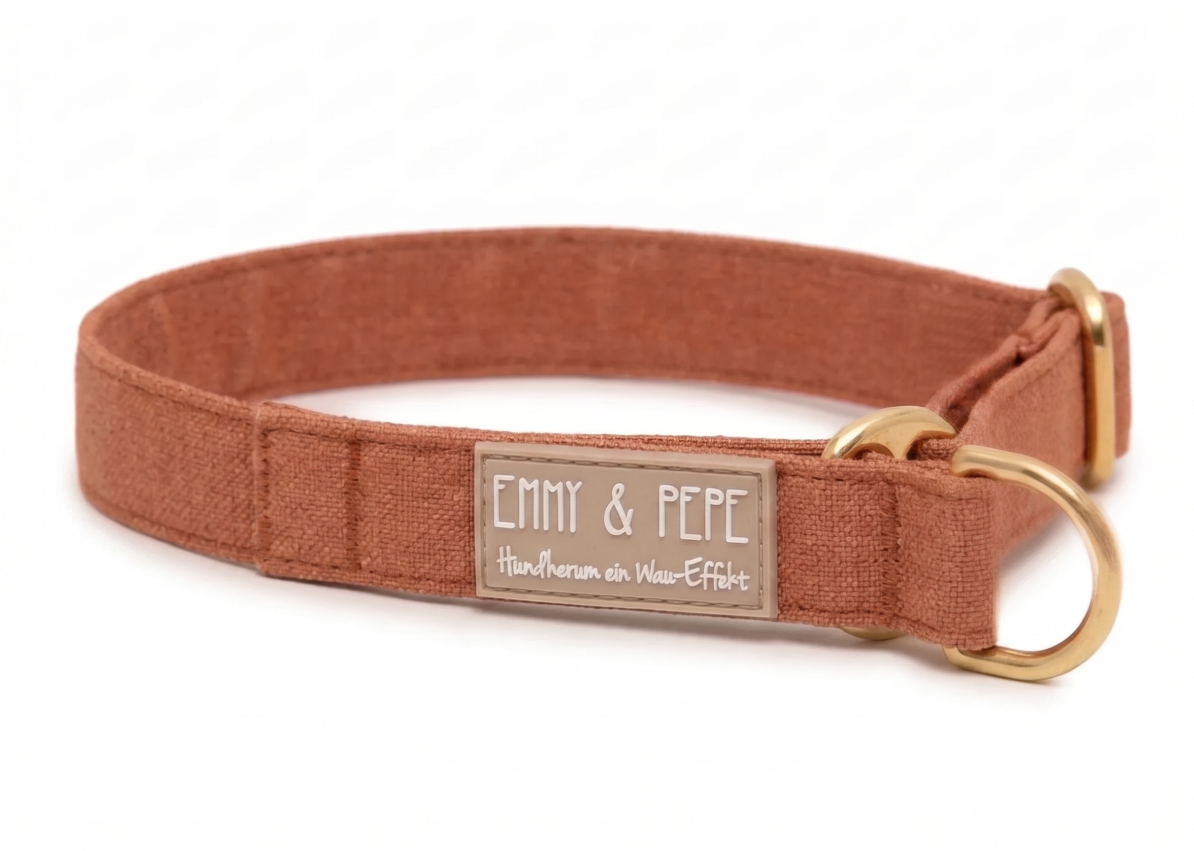 Nahaufnahme eines hochwertigen Hundehalsbands in einem warmen Braunton mit Messing-Details. Das gummierte Label zeigt den korrigierten Schriftzug „Hundherum ein Wau-Effekt“ in einer verspielten weißen Handschrift.