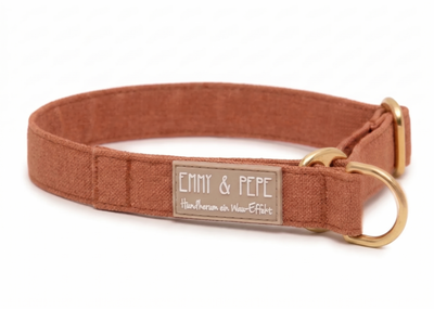 Nahaufnahme eines hochwertigen Hundehalsbands in einem warmen Braunton mit Messing-Details. Das gummierte Label zeigt den korrigierten Schriftzug „Hundherum ein Wau-Effekt“ in einer verspielten weißen Handschrift.
