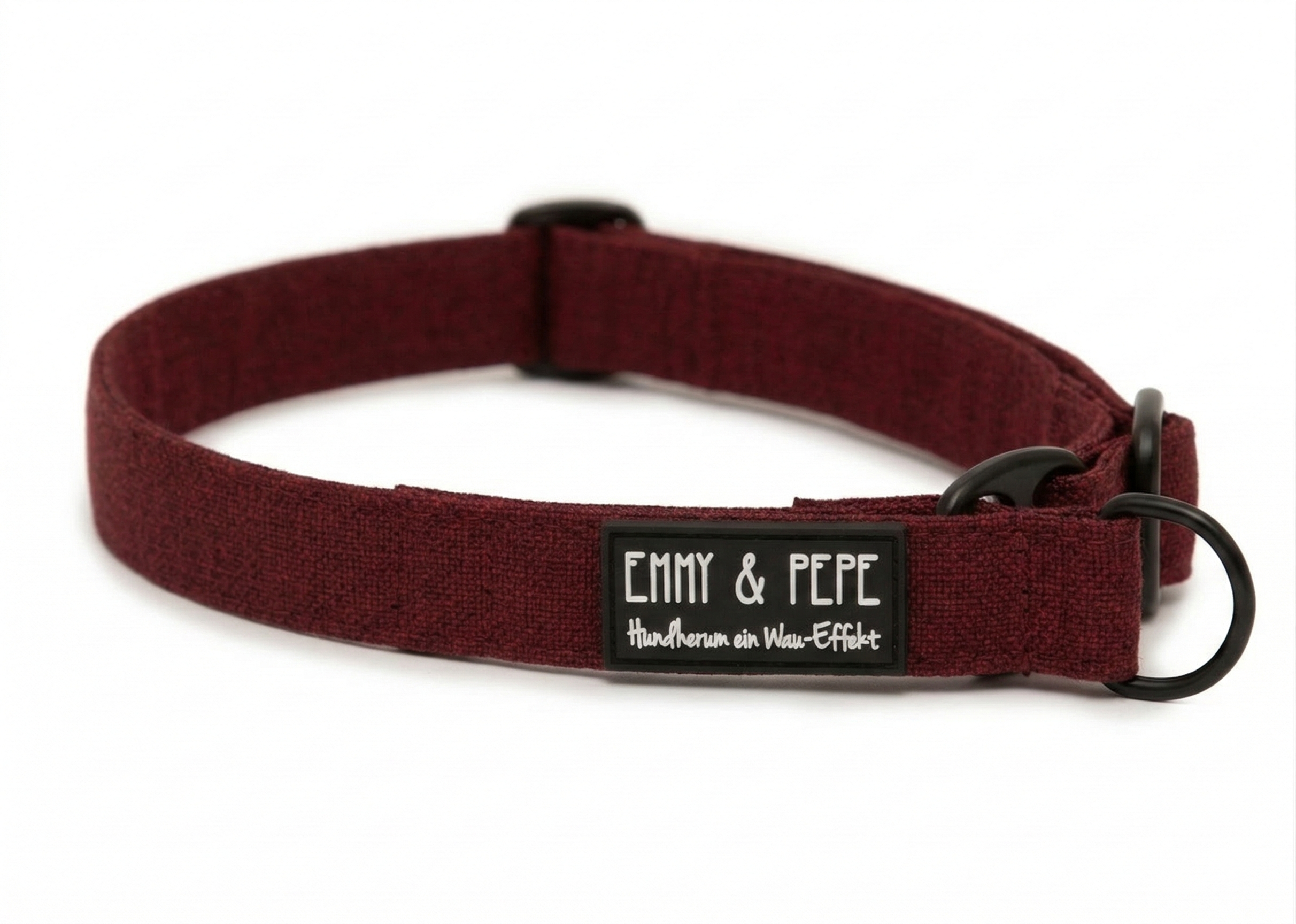 Nahaufnahme des dunkelroten Zugstopphalsbands. Der Text auf dem schwarzen Label zeigt nunden markentypischen Wortwitz „Hundherum ein Wau-Effekt“ in weißer Schreibschrift. Die schwarzen Beschläge ergänzen das edle Design.