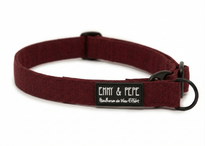 Nahaufnahme des dunkelroten Zugstopphalsbands. Der Text auf dem schwarzen Label zeigt nunden markentypischen Wortwitz „Hundherum ein Wau-Effekt“ in weißer Schreibschrift. Die schwarzen Beschläge ergänzen das edle Design.