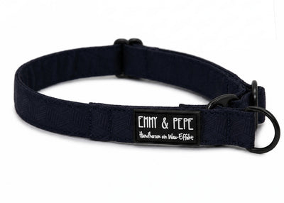 Dunkelblaues Zugstopphundehalsband mit schwarzer Metallhardware und „EMMY & PEPE“-Label mit Schriftzug „Wau-Effekt“ auf weißem Hintergrund.